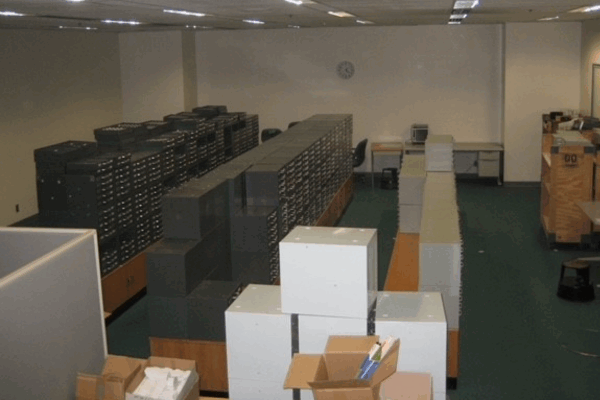 A large storage room containing long rows of black file cabinets used for organizing photographic slides.