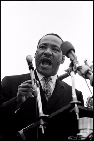 A powerful black-and-white photograph of Martin Luther King Jr. addresses the largest peace demonstration in history at the United Nations Plaza.