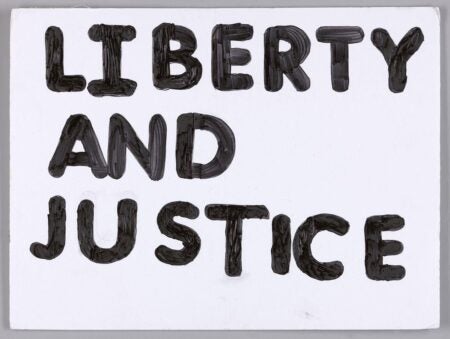 Black, painted text on a white poster board that reads ‘LIBERTY AND JUSTICE’. 