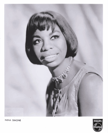 Black-and-white studio publicity portrait of a woman with a bob haircut and jeweled necklace gazing slightly upward; printed text at the bottom reads “NINA SIMONE” with a Philips logo.