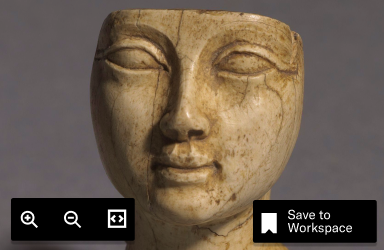 Close-up of an ancient carved sculpture head with buttons labeled Zoom and Save to Workspace.